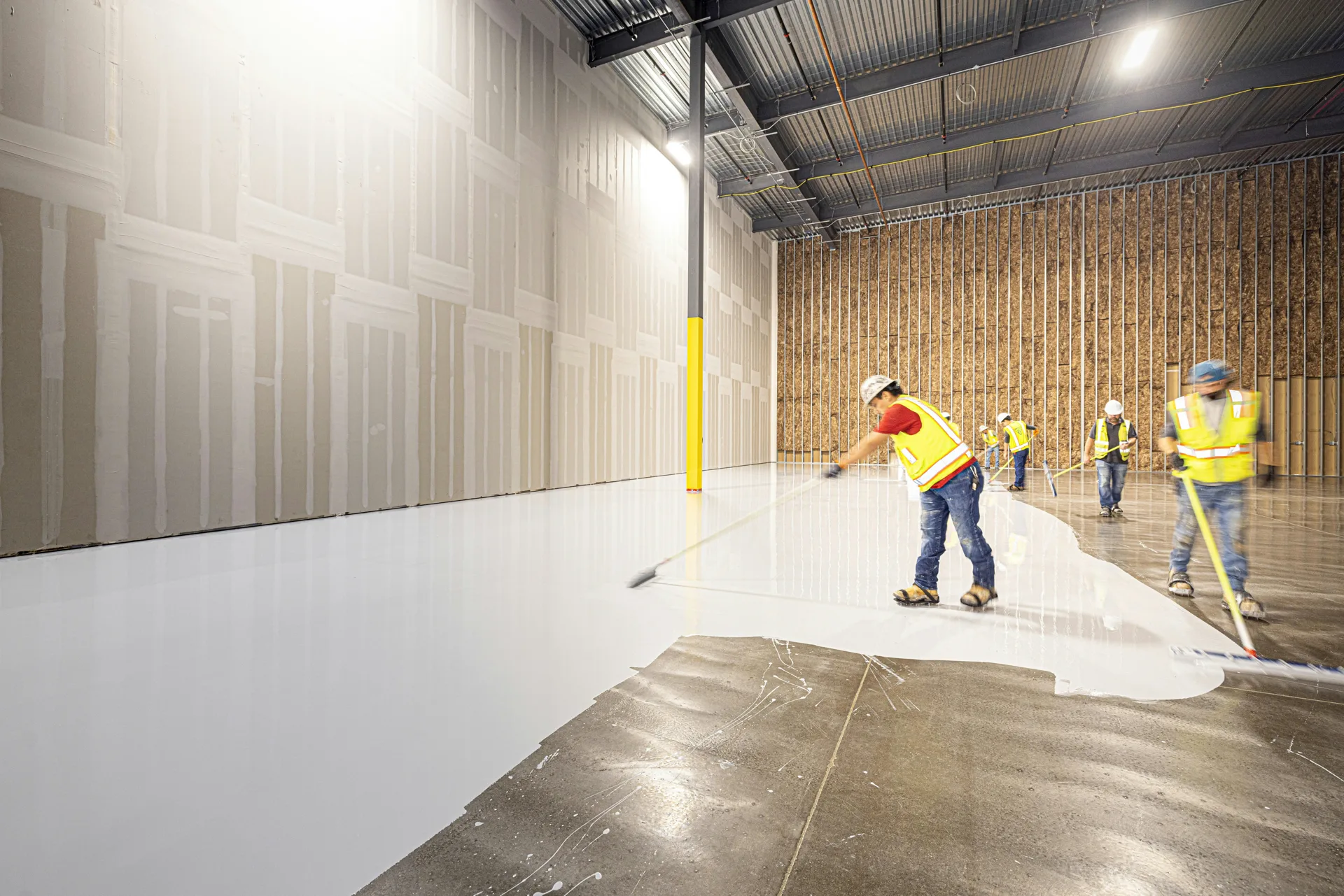 Rust-Oleum coating crew squeegeeing a base coat in Minneapolis