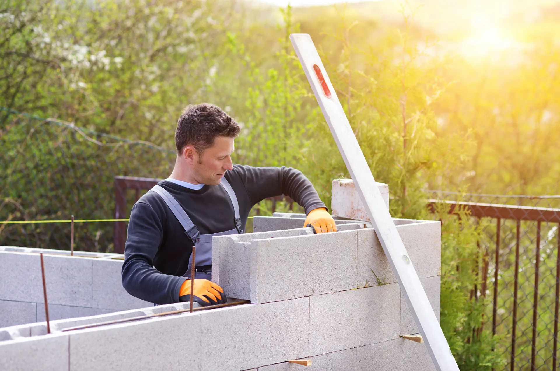 mason levelling a block retaining wall at a Minneapolis property