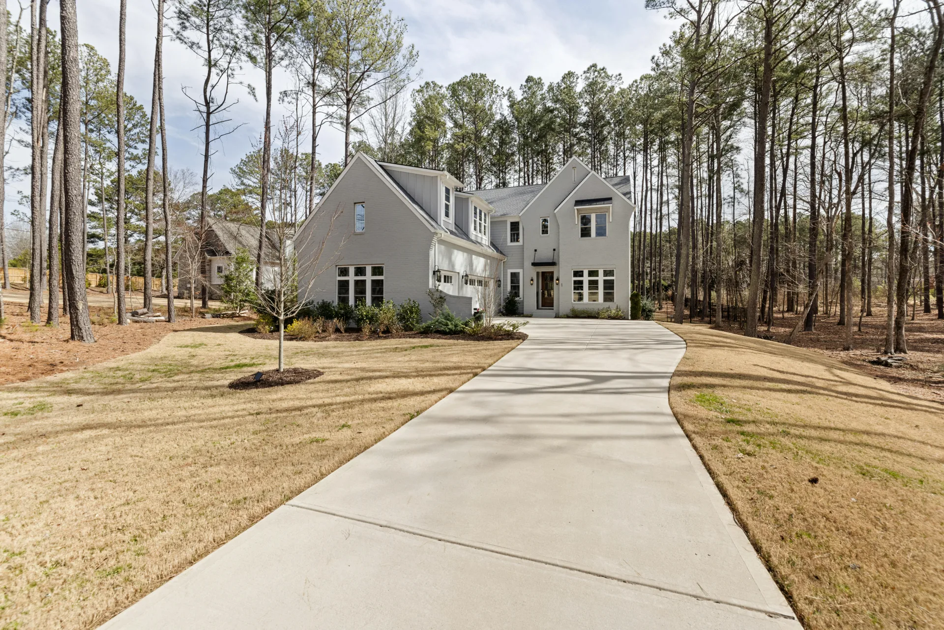 long curving concrete driveway through pines near Barrhaven