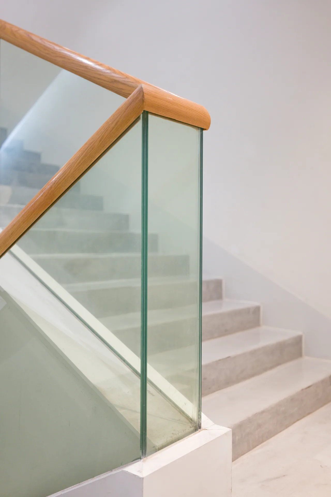 poured concrete staircase with glass railing at a Minneapolis home